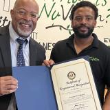 Representative Glenn Ivey presents NuVegan Cafe owner Vernon Woodland with a Congressional Citation recognizing the restaurant's positive impact on the district.
