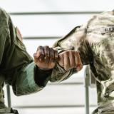 Two United States military servicemen bump fists in solidarity.