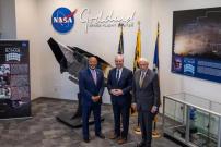 Three men in suits smiling for a photo at NASA Goddard Flight Center
